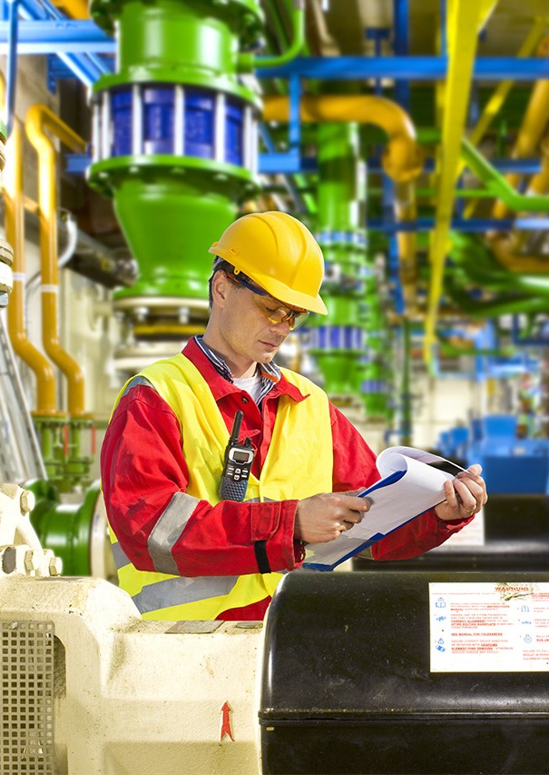 industry A large petrochemical plant at night. The plant is illuminated by many lights, and there are several tall stacks visible against a dramatic sky.