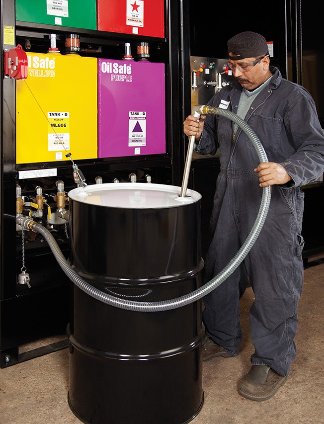 product2 A large industrial machine with four brightly colored tanks. The tanks are labeled "OilSafe" and have different colors: red, green, blue, and yellow. The machine has a black metal frame and various pipes and valves.