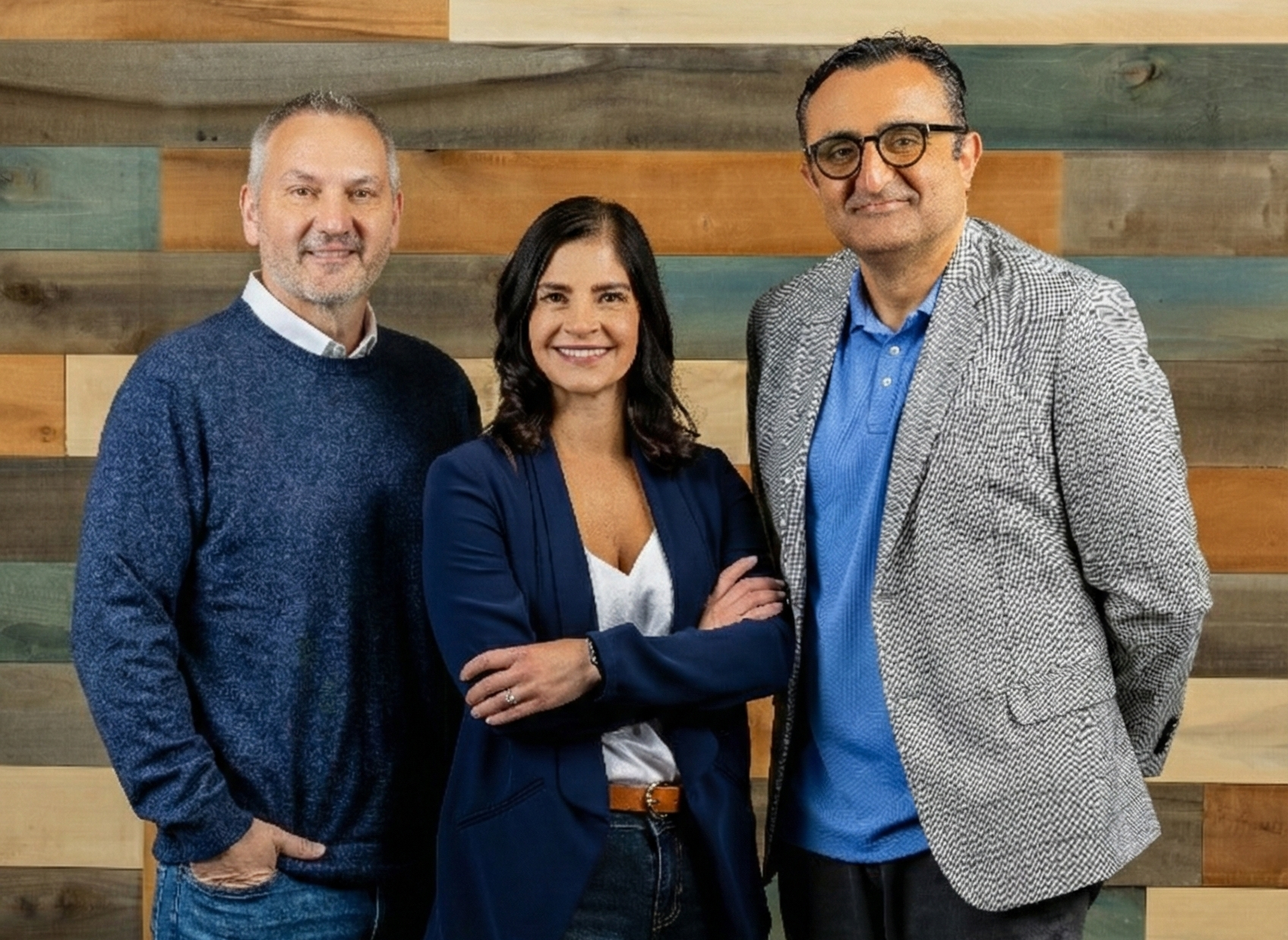 An aerial view of a winding road snaking through a dense forest. The trees are a mix of green and brown, creating a colorful patchwork effect.